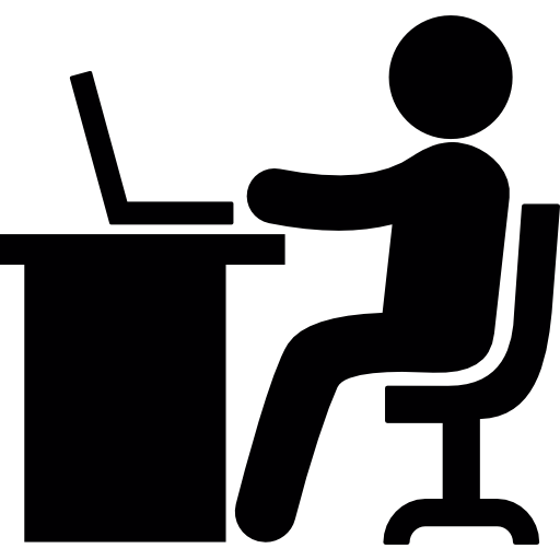 A black and white icon of a person sitting at a desk with a laptop.The person is facing the laptop and appears to be working on it.